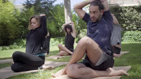 Sportive-people-performing-yoga-pose-in-park